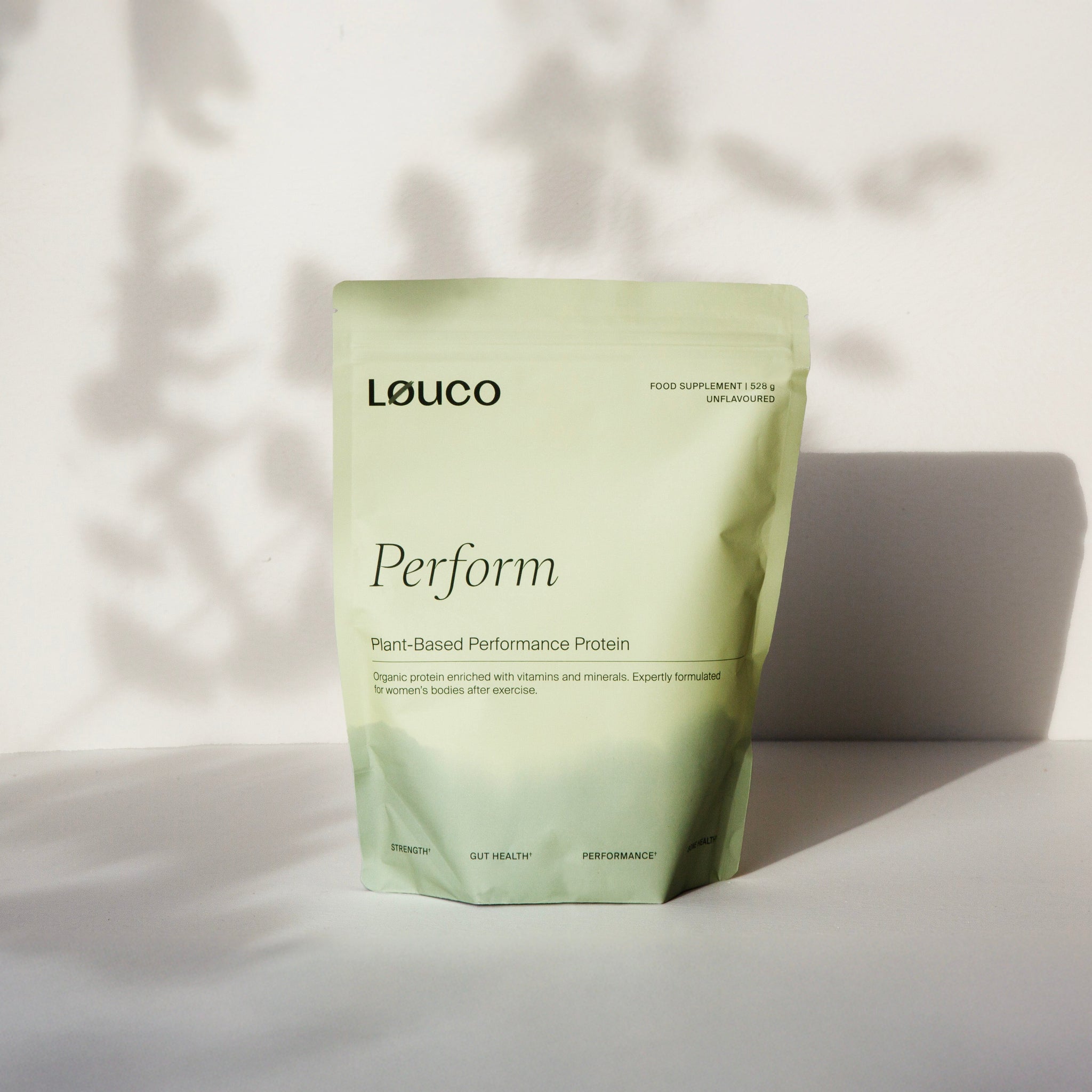 Green Løuco Perform protein powder package on a light background